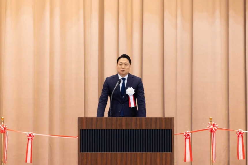 スピーチをする志倉代表